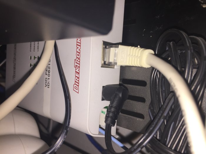 En nätverksswitch med ansluten Ethernetkabel och nätsladd, märkt Direktronik.