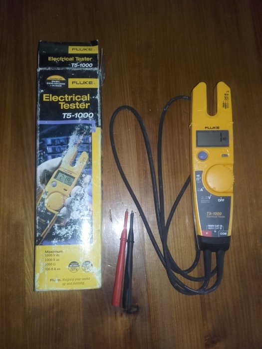 Fluke T5-1000 elektrisk tester med mätprober och originalförpackning på ett bord.