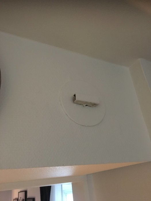 Defekt ventilationslock i tak med skadad målfärg och synligt hål.