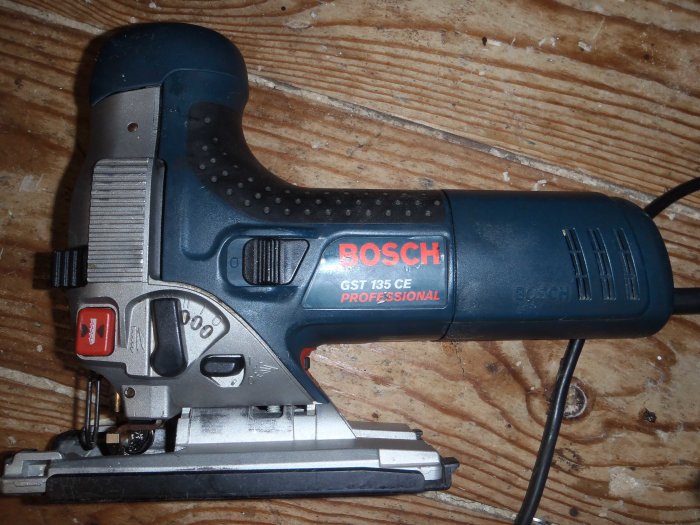 Bosch sticksåg GST 135 CE Professional på ett trägolv täckt med spånsav.