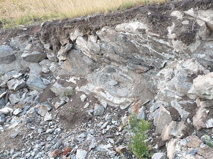 En öppen grop med blandning av jord och större stenar som behöver fyllas för byggprojekt.