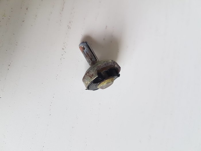 Skadad krankägla med saknad bit, rost och avlagringar mot en vit bakgrund.