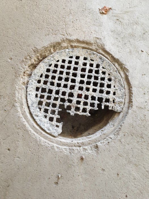 Slitet metallgaller i avlopp med 240mm diameter, inbäddat i betonggolv, behöver ersättas.