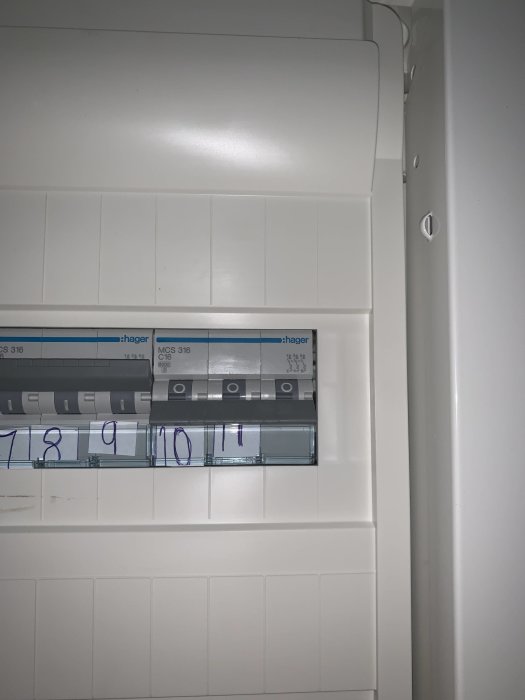 Elektrisk säkringstavla med numrerade säkringsplatser och synlig kabelföring.