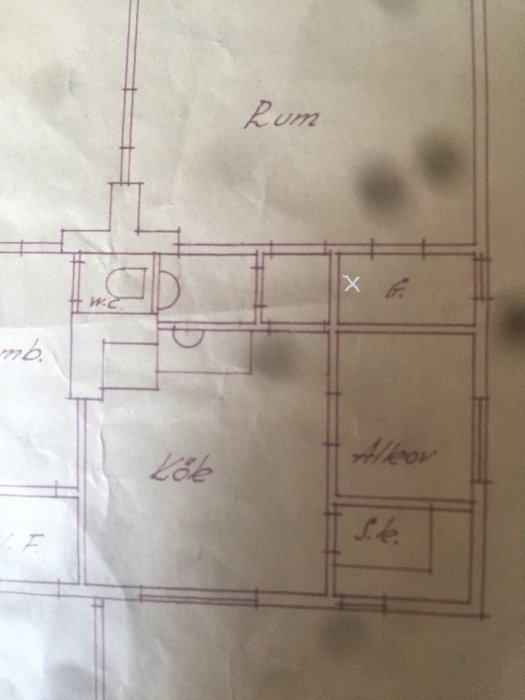 Gammal arkitektritning av en källarplan med handskrivna anteckningar och ett kryss för balkens position.