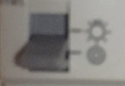 Otydlig bild av en symbol bestående av överlappande ringar bredvid en glödlampa på Hager EMD001.