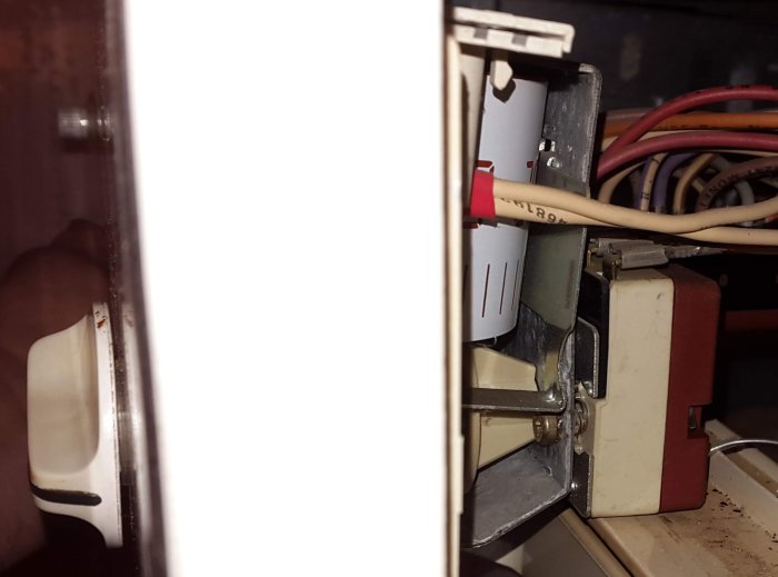 Interiör av en äldre Bosch-ugn med synligt termostatvred och elektriska komponenter.