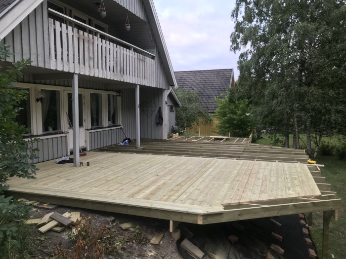 Pågående arbete med ett nytt trädäck vid huset, en del av trallen redan på plats.