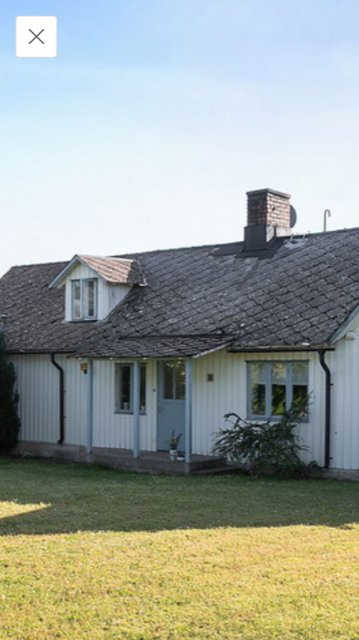 Ett hus med ett gammalt Eternit-tak som visar tecken på slitage.