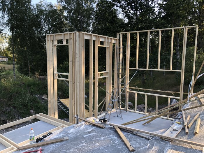 Trebjälklag och stående väggsektioner under konstruktion på en byggplats.