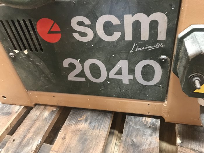 Närbild av en SCM 2040 planhyvel logotyp på maskinens sida.
