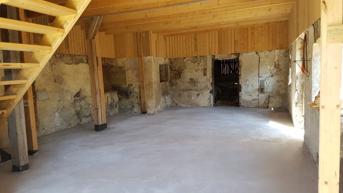 Renoverad ladugård med nygjuten betongplatta och nytt träinnertak, slaggstensväggar.