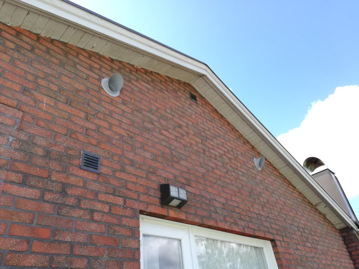 Ventilationssystem med tillufts- och frånlufsdon installerade på tegelhusets yttervägg.