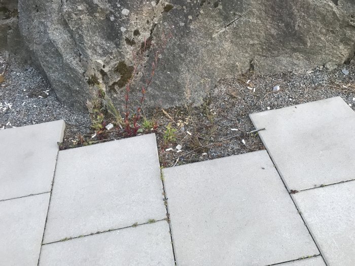 Gråa markstenar som ej är helt avslutade vid kanten av en klippa eller berg.