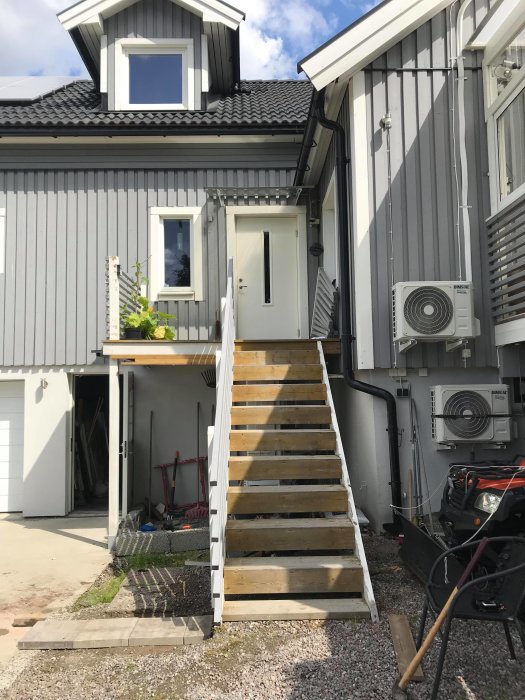 Trappa utanför ett hus som har flyttats för att ge plats för en värmepump under altanen.