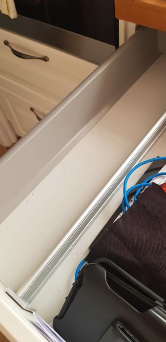 Öppen byrålåda med hög front och diverse föremål, behov av avgränsning.