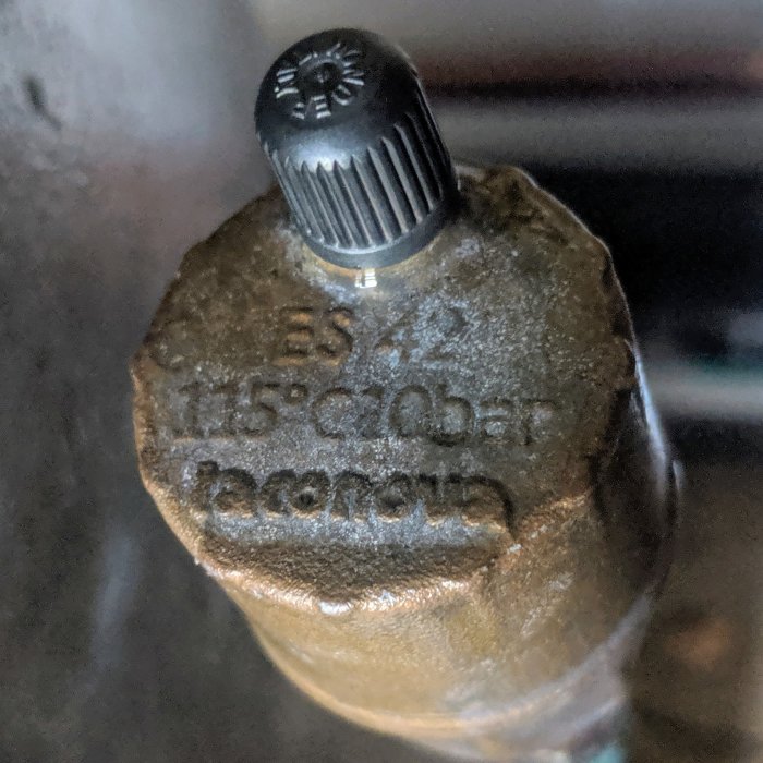 Närbild av säkerhetsventilen på en hydrofor med märkningen "ES 42 115° C10 Bar" och en ovanpå monterad ventilhatt.