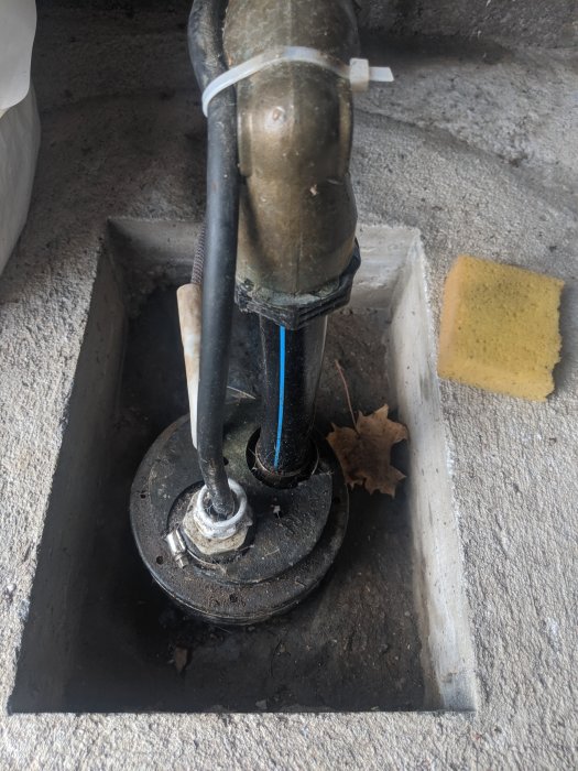 Hydrofor och rörinstallation i pumphus med synliga anslutningar och en lös avluftare.