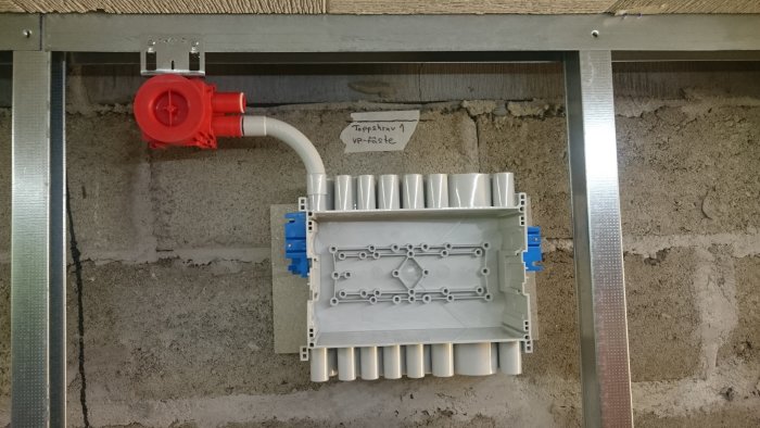 Eluttag monterat på en vägg med Cembrit-skiva, med synliga regelfästen och anslutningsrör.