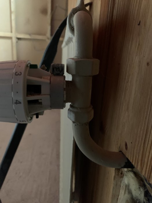 Närbild av en radiatoranslutning med 17 mm stålrör och en kopplad nippel med 26 mm lekande mutter.