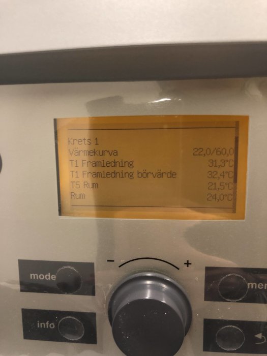 Display av en värmepumps styrenhet som visar temperaturinställningar och värden.