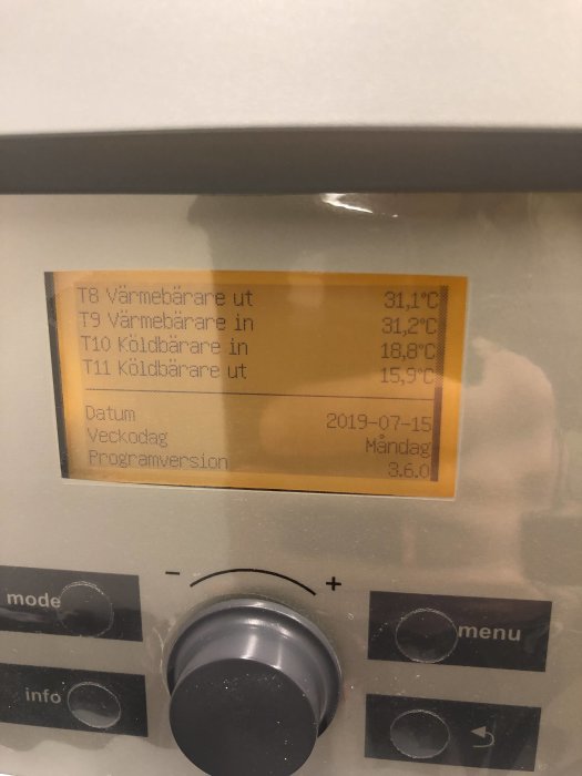 Display på en värmepump med temperaturavläsningar och inställningsreglage.