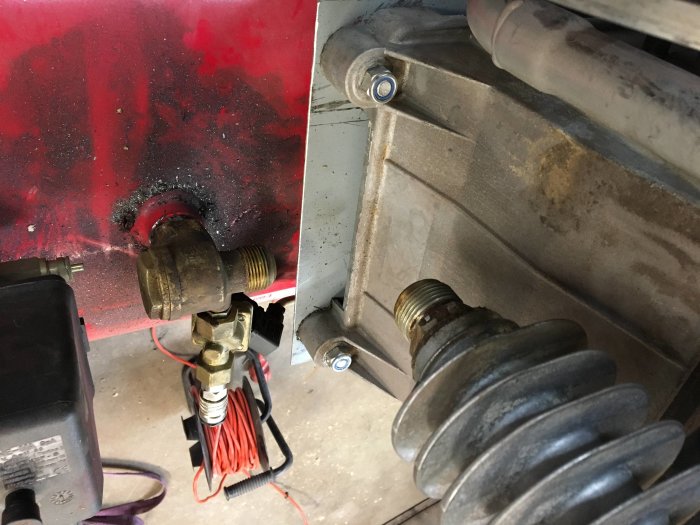 Tvådelad bild av kompressorhus monterat på tank, delvis rostig, med givare kopplad till elskåp.