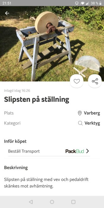 Slipsten på träställning med fotpedal och handvev ute på gräsmatta.