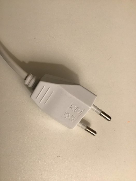 Platt vit europlugg med skruvanslutning och CE-märkning kopplad till en kabel.