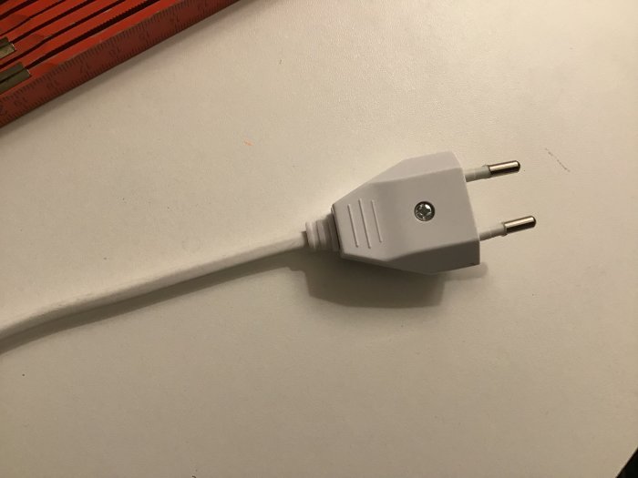 Europlugg med skruvanslutning och en bit sladd, bredvid en tumstock för storleksjämförelse.