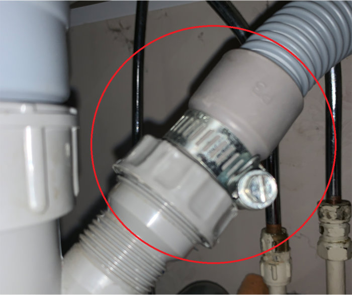 Tätningsdetalj för tvättmaskinsslang kopplad till avlopp med 32 mm gängmått markerad med röd cirkel.