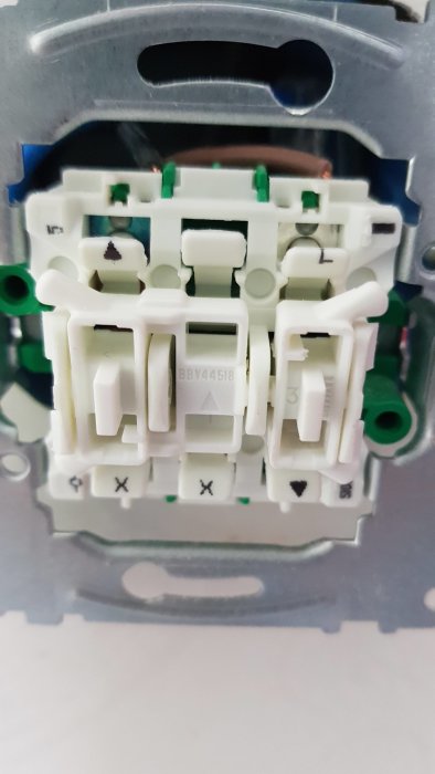 Baksidan av en strömbrytare med synliga anslutningspunkter, men utan vit kabel.