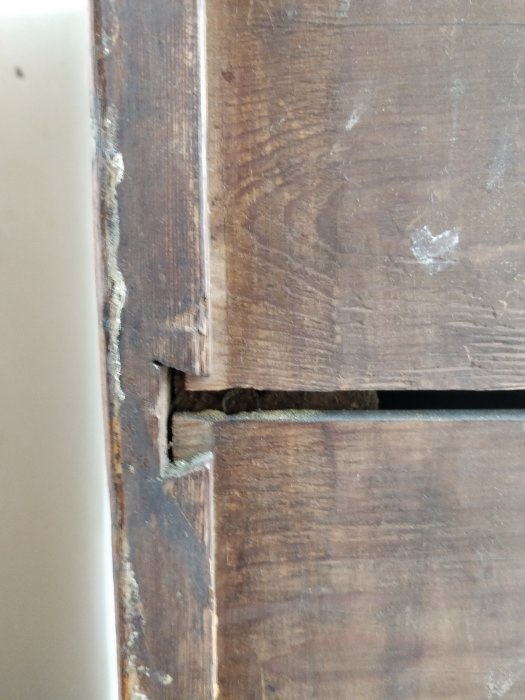 Detalj av en gammal byrås hörn med synliga laxstjärtar i träet som teknik för sammanfogning.