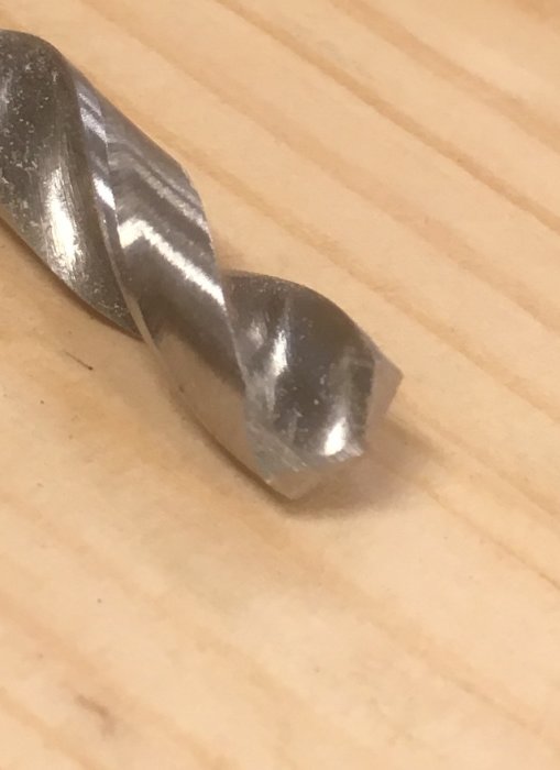 Närbild på ett slipat 8mm borr med nästan plan släppvinkel på ett träbord.