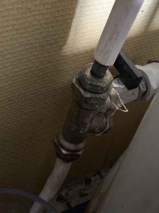 Röranslutning med gammal ventilkropp och aluminiumfolie runt läckande köksblandare.