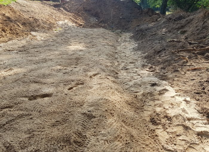 Nygrävd schaktbotten med sand/fingrus förberedd för infiltrationssystem.