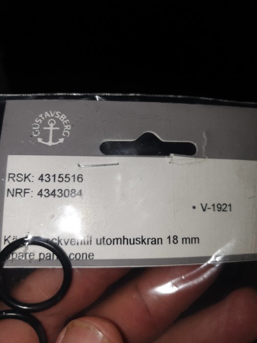 Hand håller en Gustavsberg reservdelsetikett för utomhuskran med produktnummer och en svart o-ring.