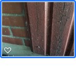 Närbild av en tegelvägg med träpanel som övergår till tegel.