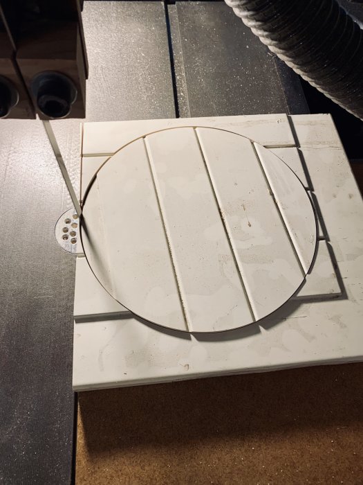 MDF-skiva med snittade cirklar för polerskiva, närbild på bandsågs cirkeljigg och polervax.
