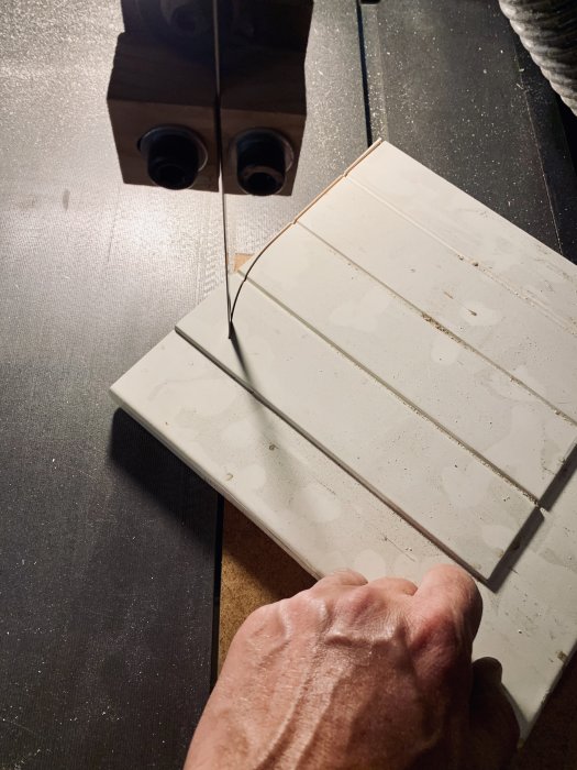MDF-skiva med spår används för slipning av knivar, med handtag synligt i förgrunden.