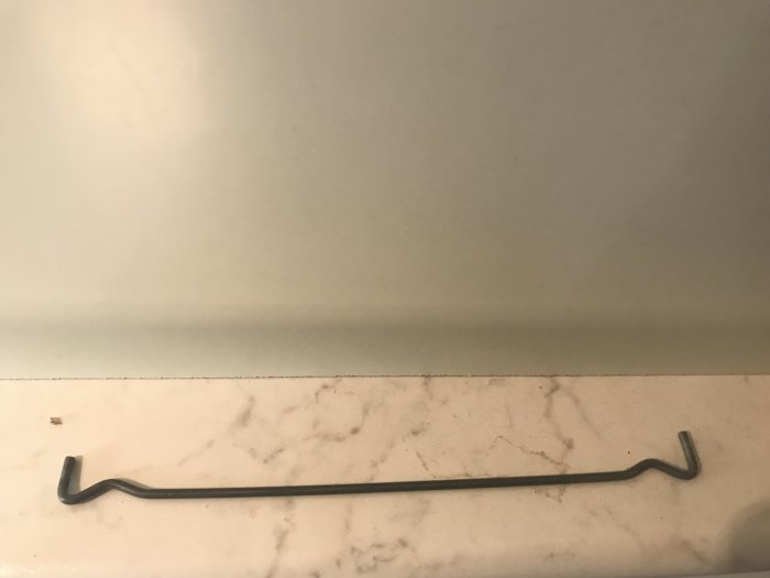 Metallhyllstöd om 21 cm långt ligger på marmorbänk, för användning i köksskåp.