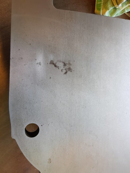 Polerat bord av en gammal rikthyvel med svarta fläckar och lite rost.