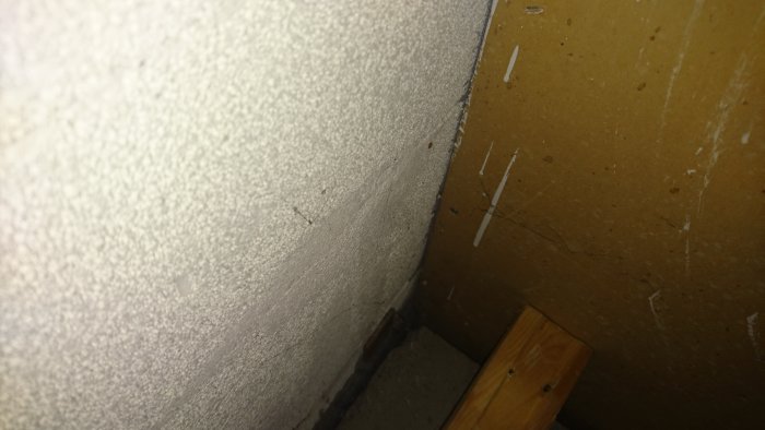 Glipa mellan betongvägg och golv i källare, där gamla golvlister tagits bort, med synlig betonghålsten och träregel.