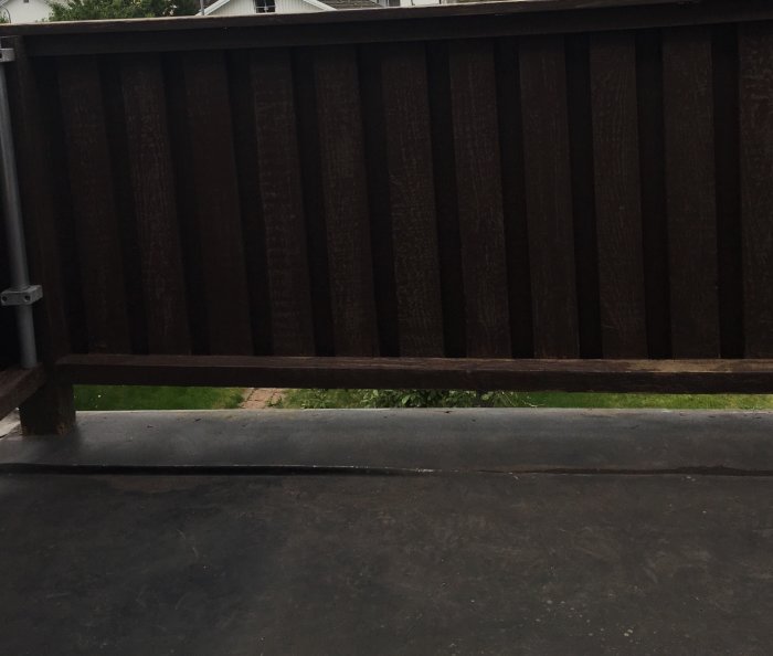 Sidosikt av ett trästaket med en synlig lucka där en mittstolpe borde vara.