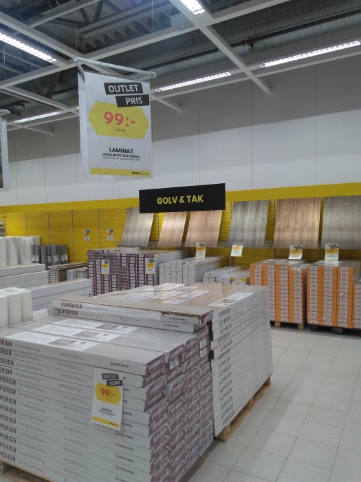 Outlet-affisch för laminatgolv med priset 99 kr i en butik under skylten "GOLV & TAK".