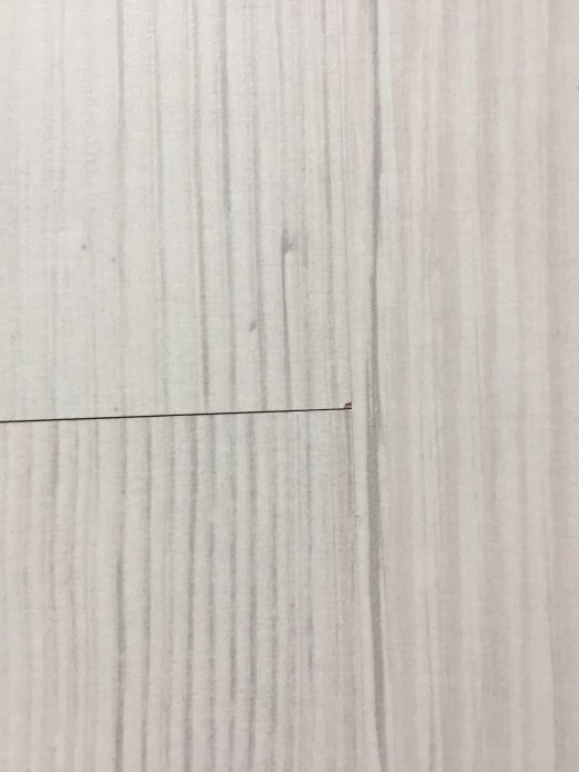 Nättillpassad skarv på ett matt, trästrukturerat Tundra-golv med synlig fiberriktning och naturlig ton.