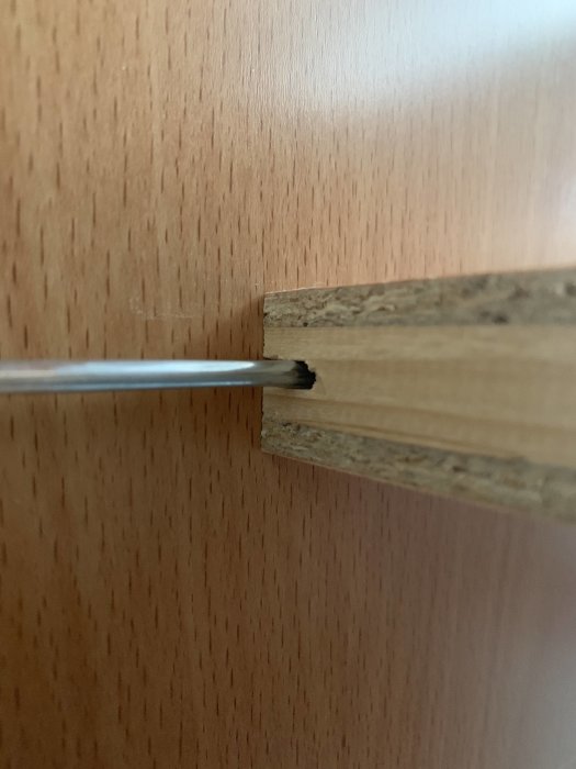 Närbild av ett hyllplan med spår för montering på en hyllbärare.