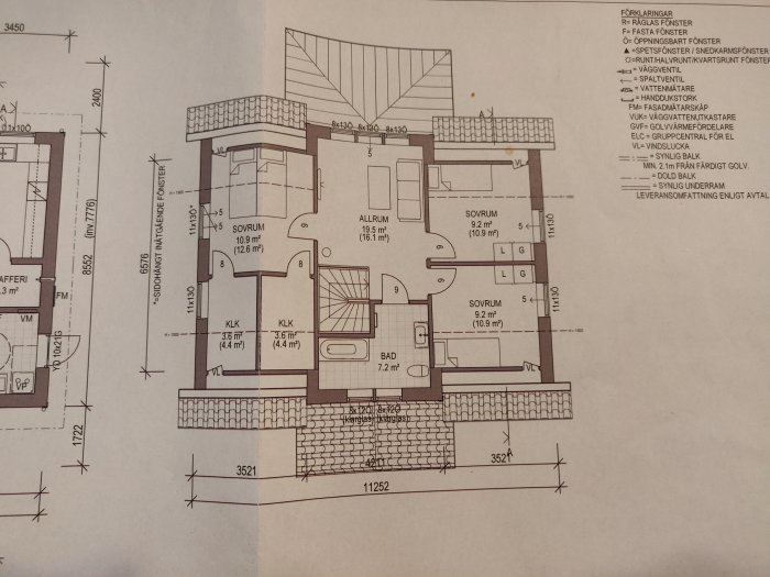 Arkitektritning av en planlösning för ett hus med markerade rum som sovrum och allrum.