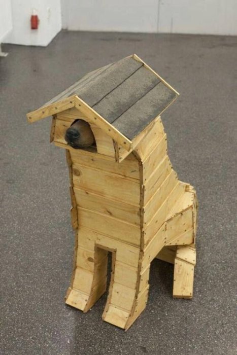 Hemmagjord hundkoja formad som en stående hund med en hund som kikar ut.
