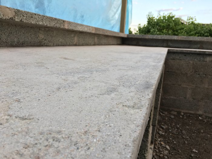 Grov och gropig hemgjuten betongbänkskiva efter slipning, med synligt slitage.